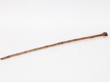 an old stick with a wooden handle sitting on a white surface