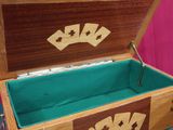une petite boîte en bois contenant quatre cartes à jouer