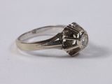 a close up of a diamond ring on a white surface