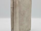 an old book sitting on top of a white table next to a white wall