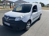 the small white van is parked on the side of the road