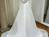 a wedding dress on a mannequin stand in front of a mirror