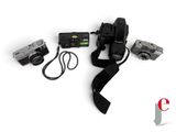 a camera, a camera strap, and a camera on a white surface