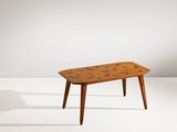 une table basse avec un plateau en bois posé sur un piètement blanc