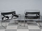 deux fauteuils en cuir noir placés l'un à côté de l'autre sur un sol à carreaux