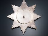 a silver snowflake on a black surface