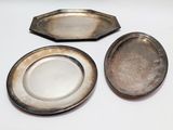 two silver plates and a silver tray on a white surface
