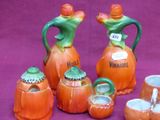 a group of ceramic pumpkin shaped items on a purple background