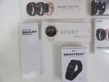 several smart watches are displayed on a white surface next to a box