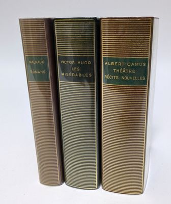 trois livres superposés sur une surface blanche