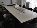 une longue table entourée de nombreuses chaises dans une pièce