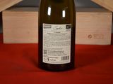 a bottle of wine sitting on a table next to a wooden box