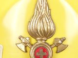 a yellow hard hat with a red cross and firefighter ' s emblem on it