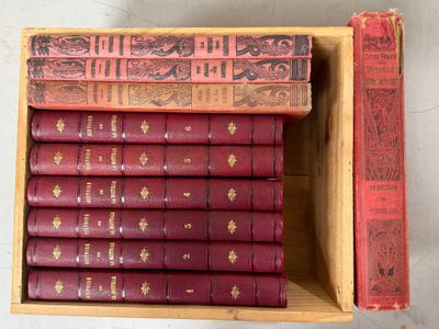 de nombreux livres rouges dans une boîte en bois posée sur une table