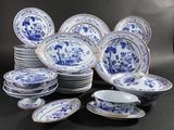 blue and white china plates and bowls are arranged on a black surface