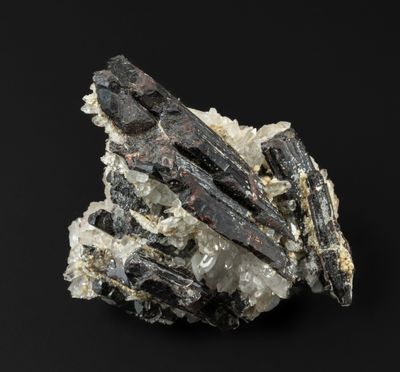 un gros plan d'un morceau de roche parsemé de cristaux sur fond noir