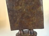 a bronze sculpture of a square object on a stand