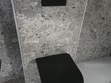 des toilettes noires situées dans une salle de bains, à côté d'une douche