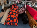 many rolls of fabric on the floor in a room