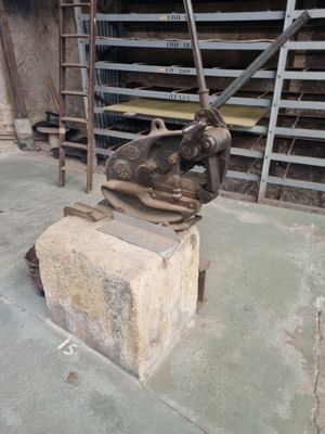 une statue représentant un homme tenant un marteau sur un bloc