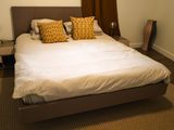 un lit sur lequel sont posés une couette blanche et des oreillers