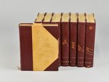 three brown books with gold bindings sit on top of each other