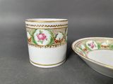 pair of porcelain cups and saucers with floral designs on them