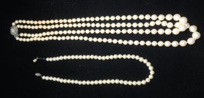 gros plan d'un collier de perles sur une surface noire