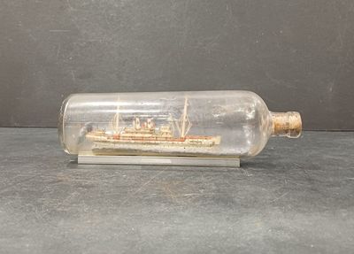 une bouteille contenant un bateau, posée sur une table