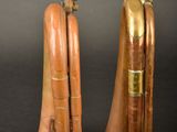 pair of antique brass trumpets on a black background