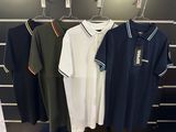 three men ' s polo shirts hanging on a rack in a store