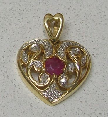 une image représentant un pendentif en forme de cœur orné d'un rubis au centre