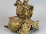 bronze figurine of a man sitting on a rock with a pot
