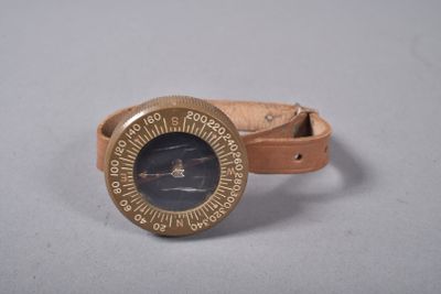 une montre avec un bracelet en cuir posée sur un fond blanc