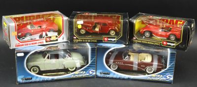 four toy cars are in a box on a black surface