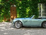 a blue sports car parked in front of a house