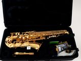a saxophone in a black case on a white surface