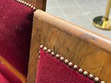 a close up of a wooden bench with a red seat