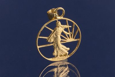 un gros plan sur un pendentif plaqué or représentant une femme à l'intérieur d'un cercle