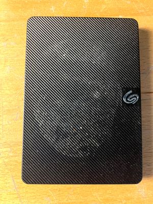 un gros plan sur un cahier noir posé sur une table en bois