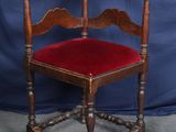 une vieille chaise en bois avec une assise en velours rouge sur fond bleu