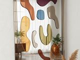 un miroir accroché au mur au-dessus d'une table sur laquelle se trouve un vase