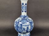an old blue and white vase with a picture of a boat in the water