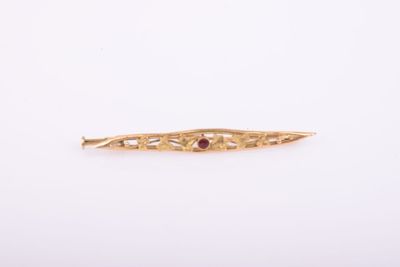une photo d'une barrette dorée ornée d'une pierre rouge