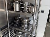 many pots and pans on the shelves in the kitchen
