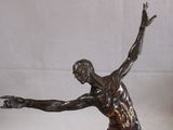 bronze statue of a man holding a tennis racquet on a marble base