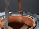a person using a pair of scissors to cut a piece of leather