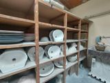 many plates and bowls on the shelves in the room