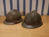 pair of wwii era german steel helmets on a wooden table