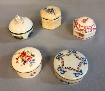 quatre petites boîtes ornées de motifs floraux posées sur une table